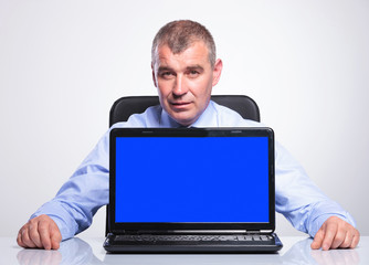 Wall Mural - old business man at desk with empty screen laptop