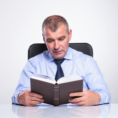 Wall Mural - senior business man reads at his desk