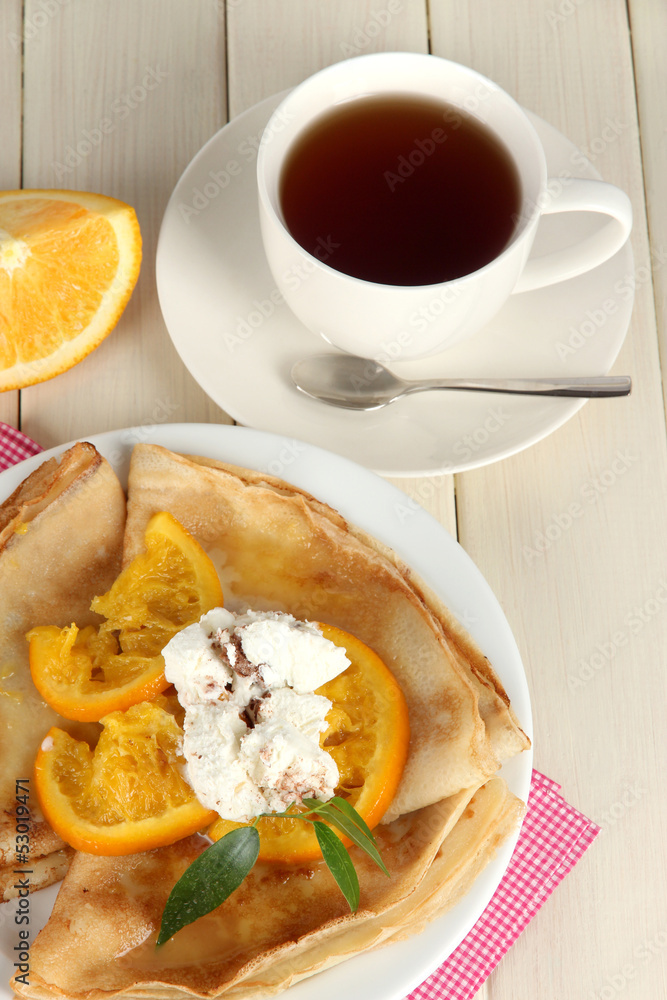 Pancakes with orange on  wooden table