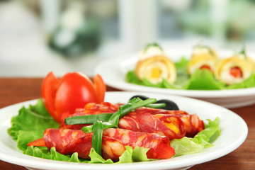 Poster - Salami rolls on white plate on bright background