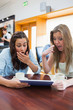© WavebreakmediaMicro - Women looking surprised while holding a tablet