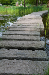  Steinbrücke auf einem Teich im Park