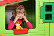 Dziewczynka w przedszkolu w oknie małego domku.