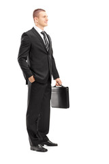 Poster - Full length portrait of a young businessman with briefcase posin