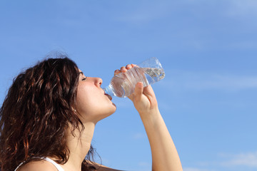  Profile of a woman drinking water from a plastic bottle