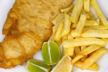 Salted french fries with large serving of fried fish with lemon