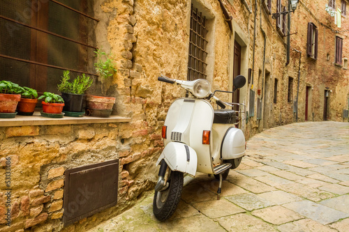 Fototapeta na wymiar Old Vespa scooter on the street in Italy