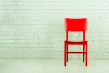 Red Chair In Empty Room Against A Brick Wall With Copy-space