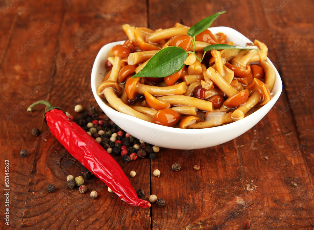 Mushrooms in bowl, on wooden background