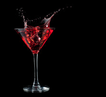 Red Cocktail Splashing Into Glass On Black