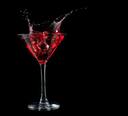 Wall Mural - red cocktail splashing into glass on black