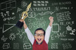 © Creativa Images - Happy student boy hold trophy in class
