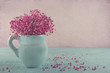 Pink baby's breath flowers in a blue jug
