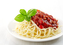 Spaghetti Bolognese And Green Basil Leaf On White Plate