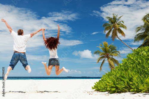 Nowoczesny obraz na płótnie Happy couple jumping on the tropical beach