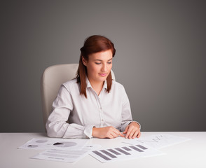 Businesswoman sitting at desk and doing paperwork