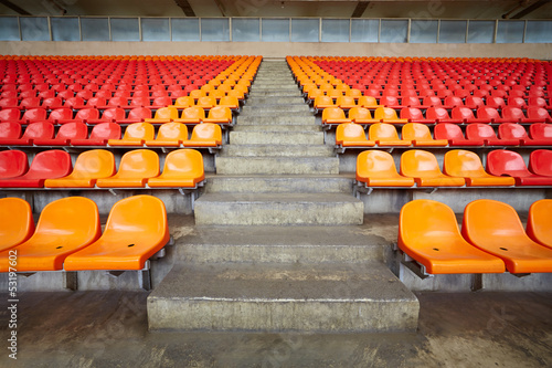 Fototapeta na wymiar Rows of red and orange plastic sits at stadium