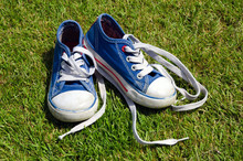 Old Sneakers On Grass Background