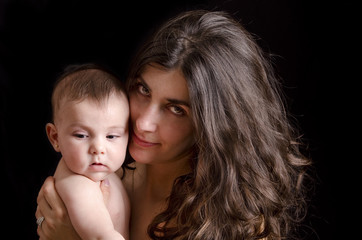 low key portrait of mother and baby.black background.