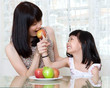 © szeyuen - asian mother and daughter sharing an apple