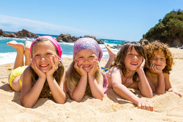 Kids laying on the beach.