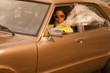 Vintage 70s fashion afro woman with sunglasses driving in brown