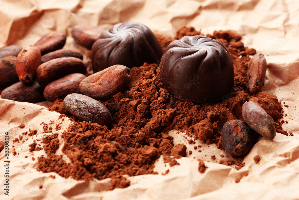 Composition of chocolate sweets and cocoa on brown background