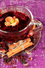 Herbal tea in glass cup, on color wooden background