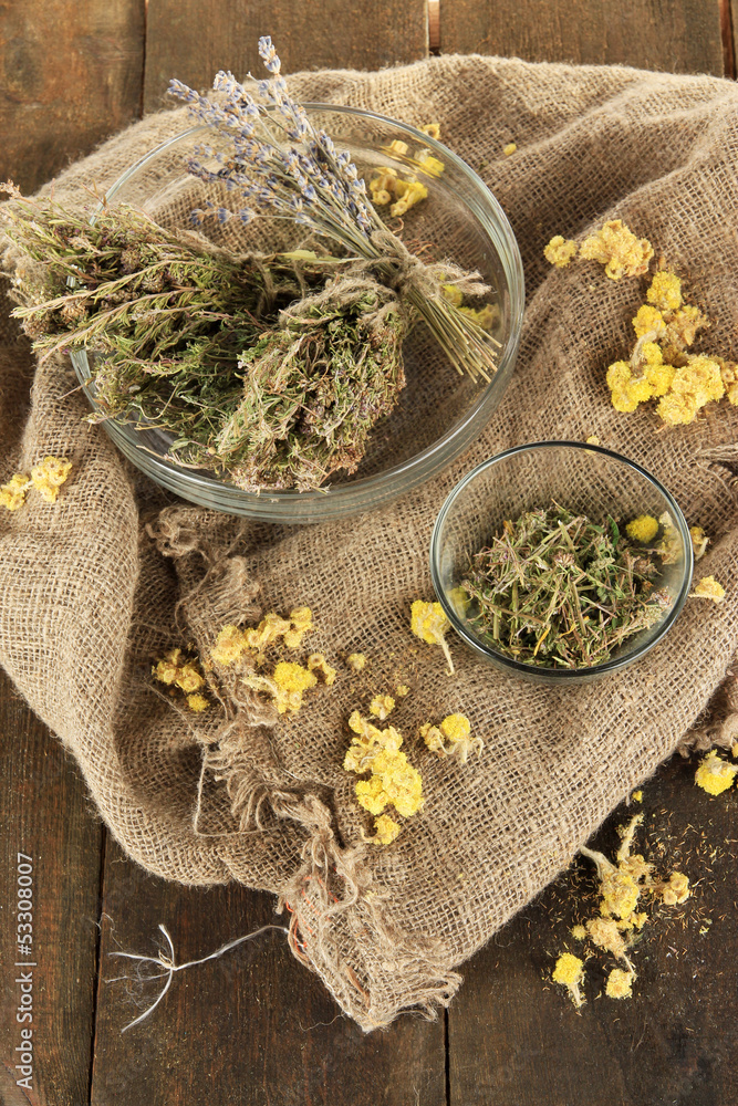 Medicinal Herbs in glass bowls on bagging close-up