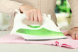 © Africa Studio - Woman's hand ironing clothes, on bright background