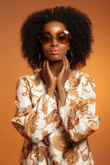 Retro 70s fashion african woman with paisley dress and sunglasse