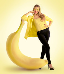 Woman standing next to a large banana