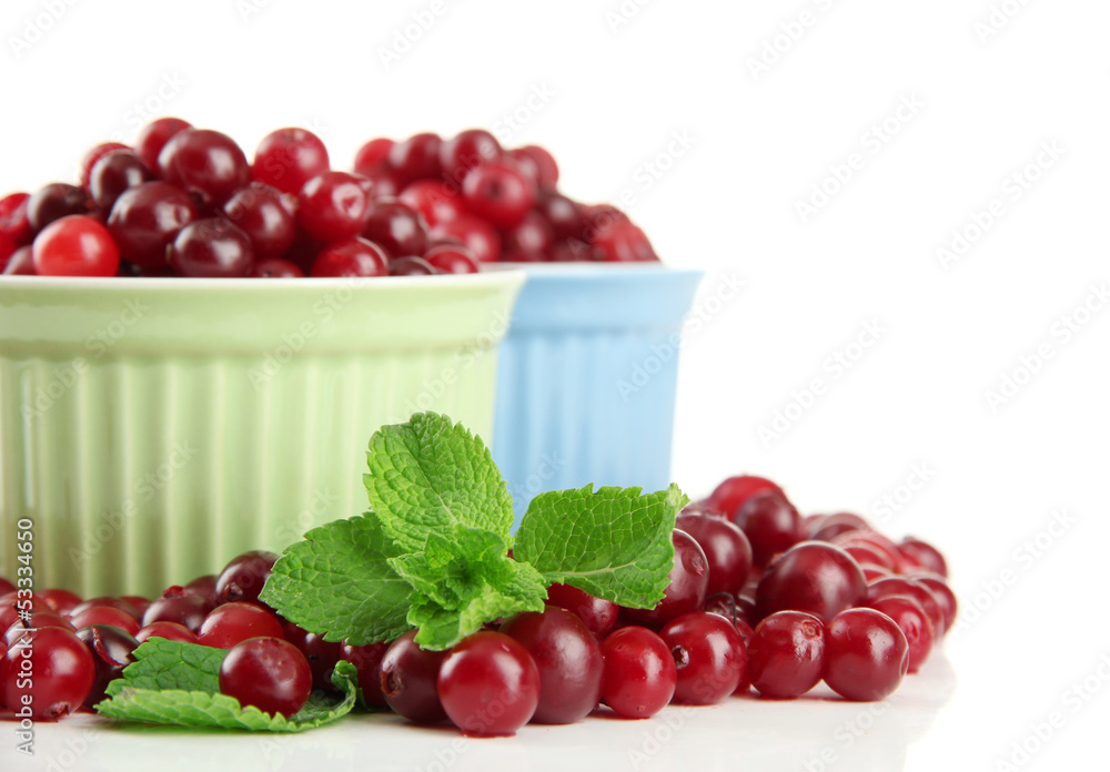 Ripe red cranberries in bowls, isolated on white.