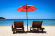 Два лежака и зонт от солнца на песчаном пляже