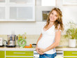 © Ermolaev Alexandr - Portrait of beautiful pregnant woman holding belly in kitchen