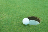 Fototapeta  - A golf ball very close to a hole