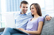 © pikselstock - Couple on sofa with laptop