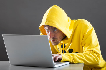 man in a yellow jacket working on the Internet