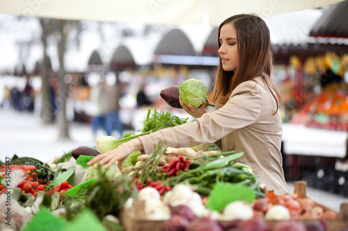Fotografía Young woman picking vegetables at farmer's market
