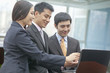 © xixinxing - Three Business People Looking at Laptop