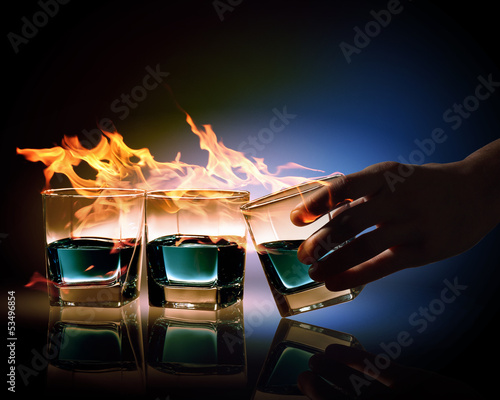 Fototapeta na wymiar Three glasses of burning emerald absinthe