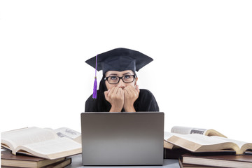 Wall Mural - Beautiful graduate afraid in front of laptop