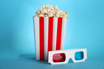 Popcorn and 3D glasses on blue background