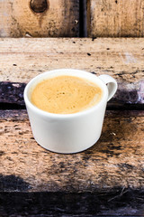 Poster - Cappuccino coffee cup with foam on white saucer on Old vintage d