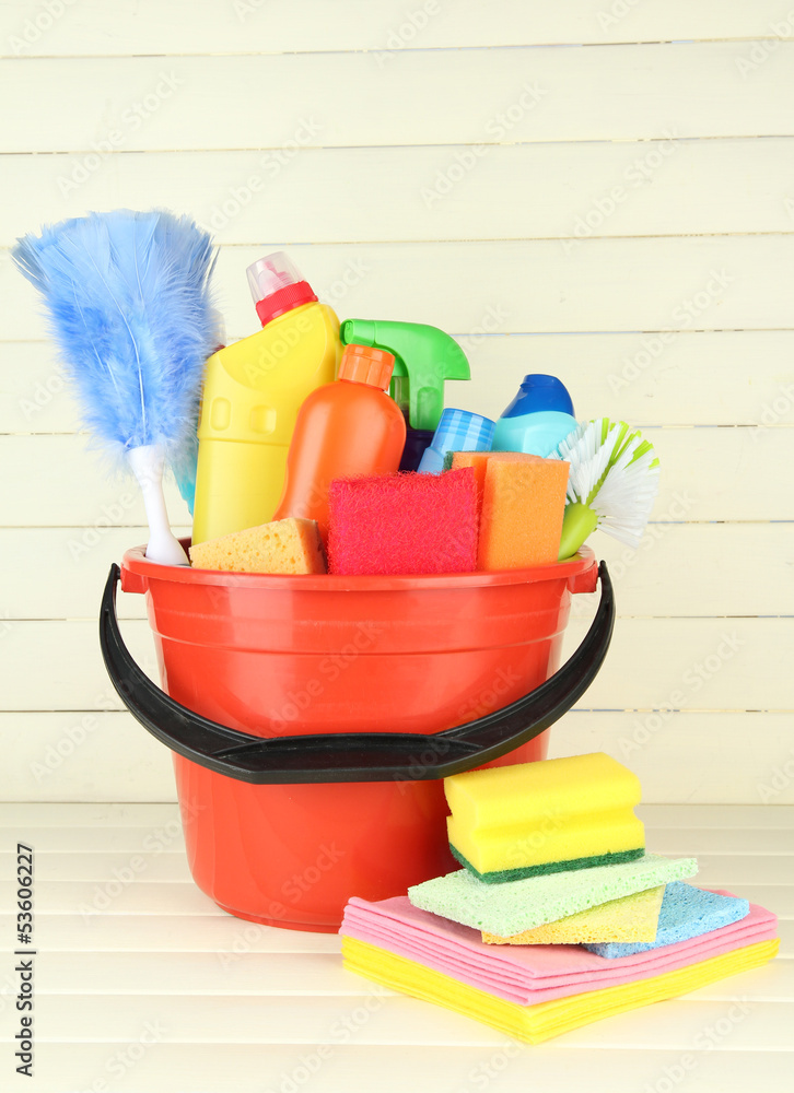Cleaning items in bucket on  white wooden background