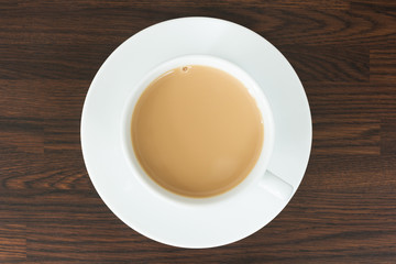 Overhead view of tea in a cup and saucer on wood