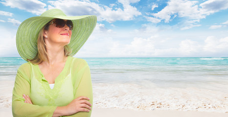 Senior woman wearing sunglasses and a hat.