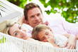 © Monkey Business - Family Relaxing In Beach Hammock With Sleeping Daughter