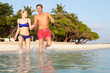 © Monkey Business - Couple Splashing In Sea On Tropical Beach Holiday