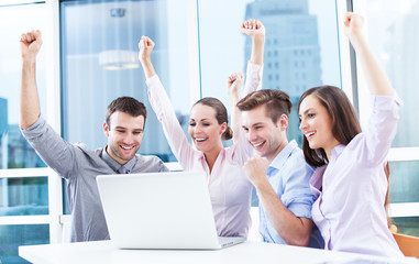 Business people cheering at laptop